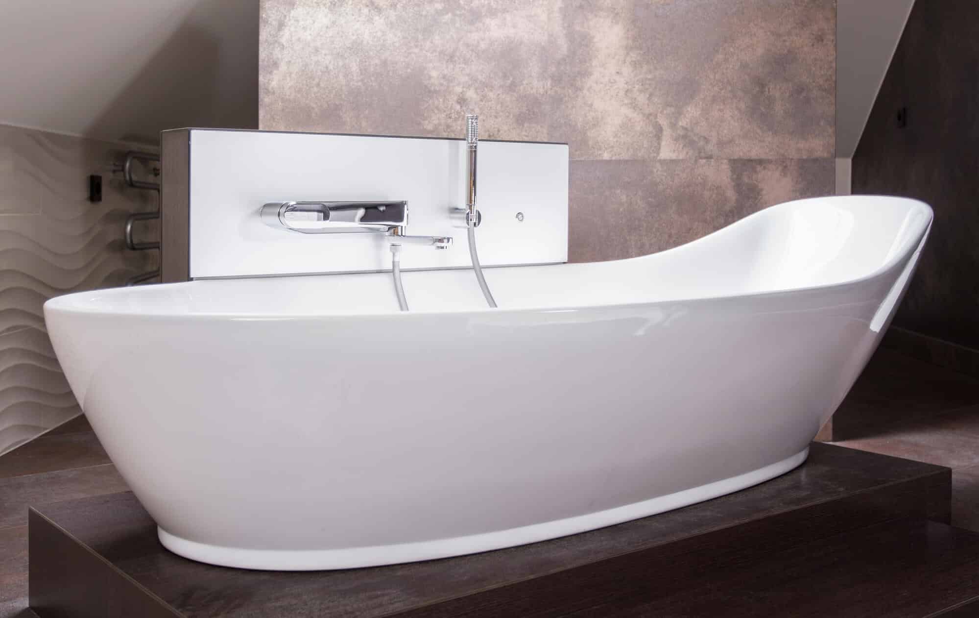 A white bath tub sitting on top of a wooden floor