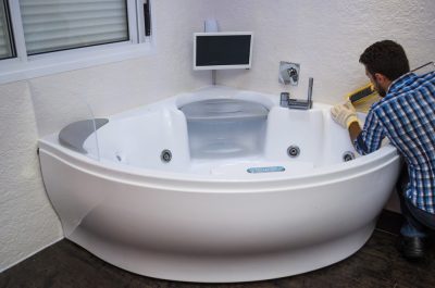 Installation of modern bath, (hot tub), applying sealant, bathtu