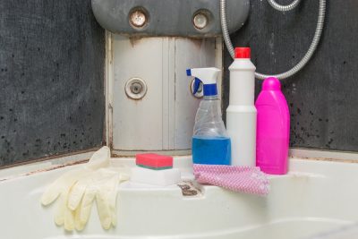 very dirty shower with mold at the joints. There are detergents, sponges and gloves to remove dirt and limescale. The concept is cleaning services, general cleaning, cleaning from old dirt.