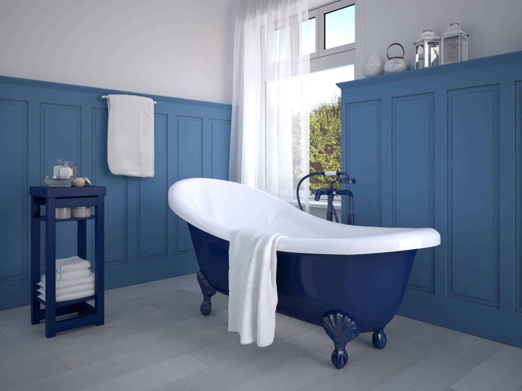 Navy clawfoot tub against blue paneled walls