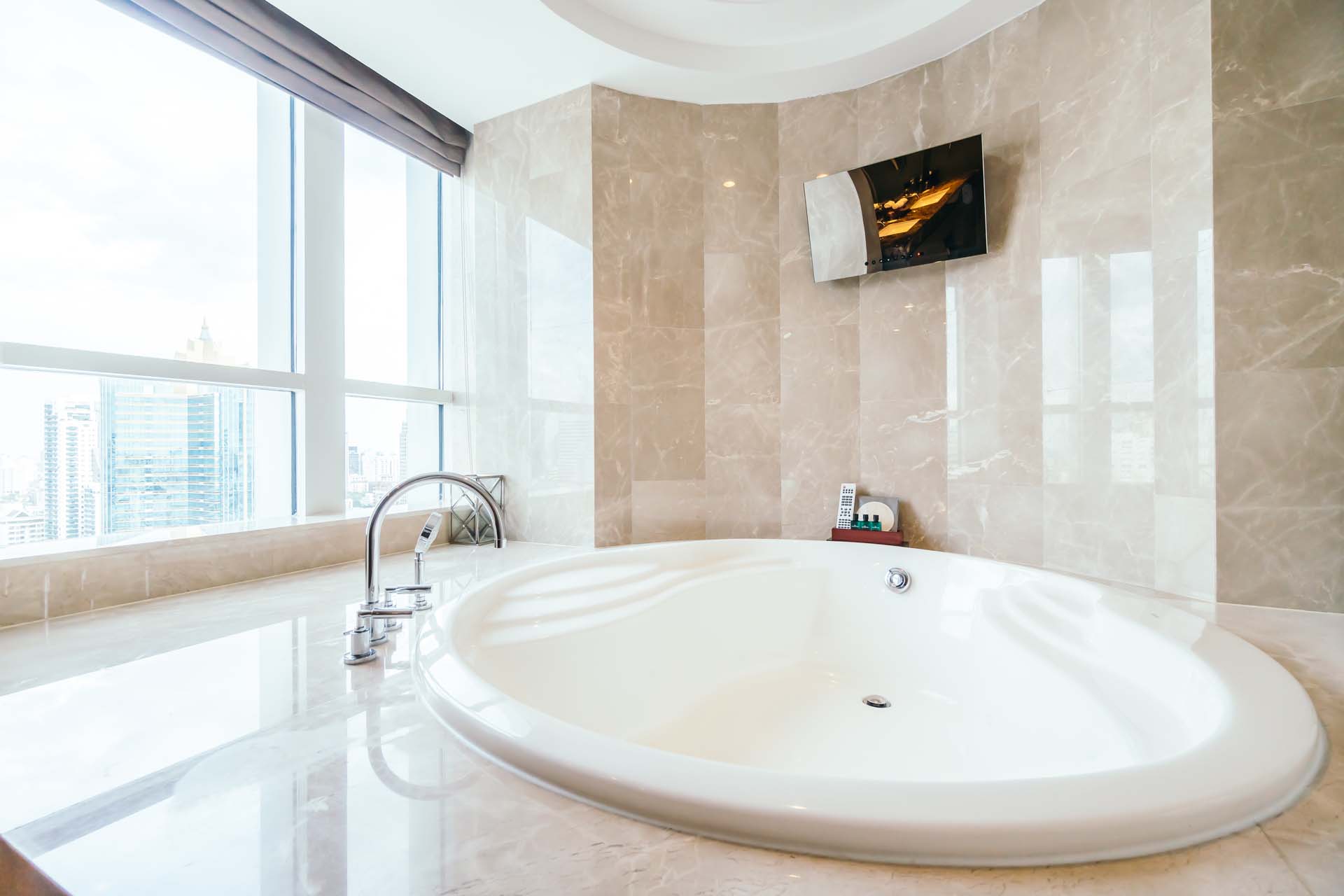 Built-in corner bathtub in a beige bathroom