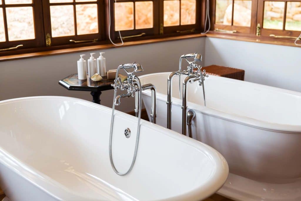 Freestanding tub with a chrome floor-mounted faucet